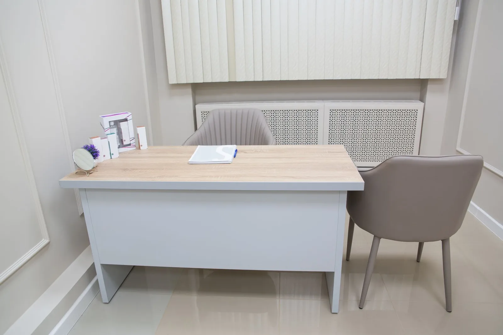 Clean and organized medical office desk with chairs and equipment, perfect for healthcare settings.