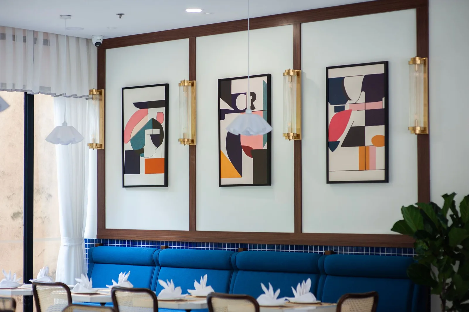 Stylish restaurant interior featuring blue seating and abstract artwork on the walls.
