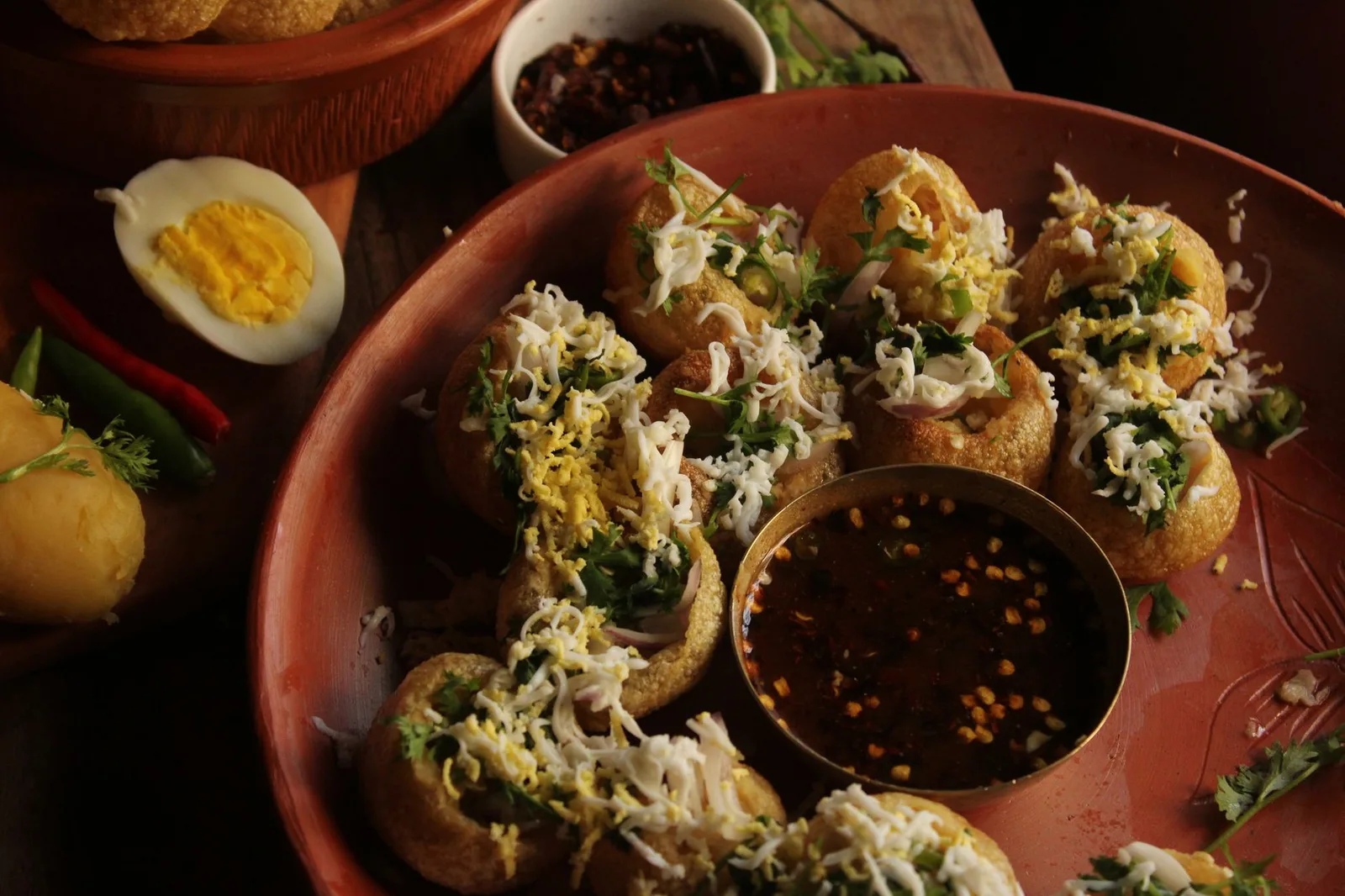 A mouthwatering platter of Indian Pani Puri topped with coriander and served with spicy chutney.