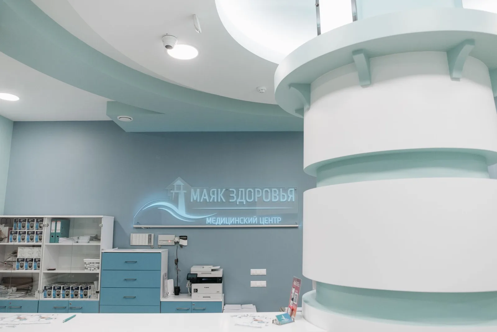 Interior of a modern clinic with teal and white design elements, emphasizing healthcare ambience.