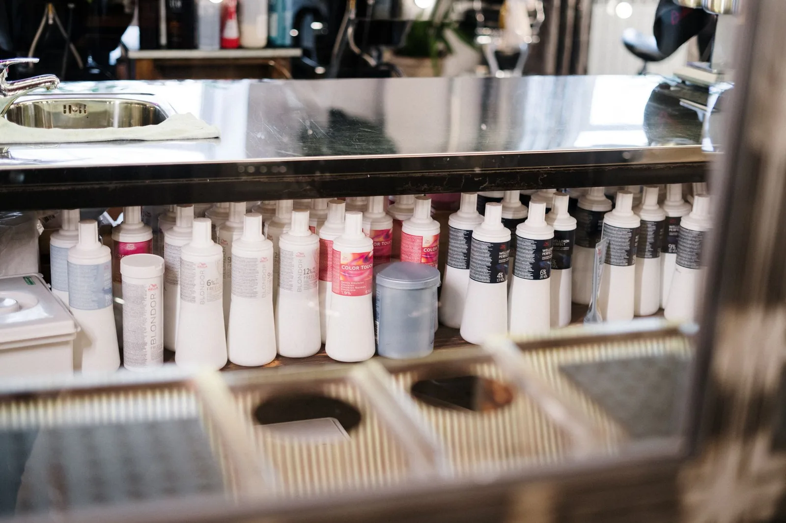 A neat arrangement of hair care products on a salon shelf. Ideal for hairstyling concepts.