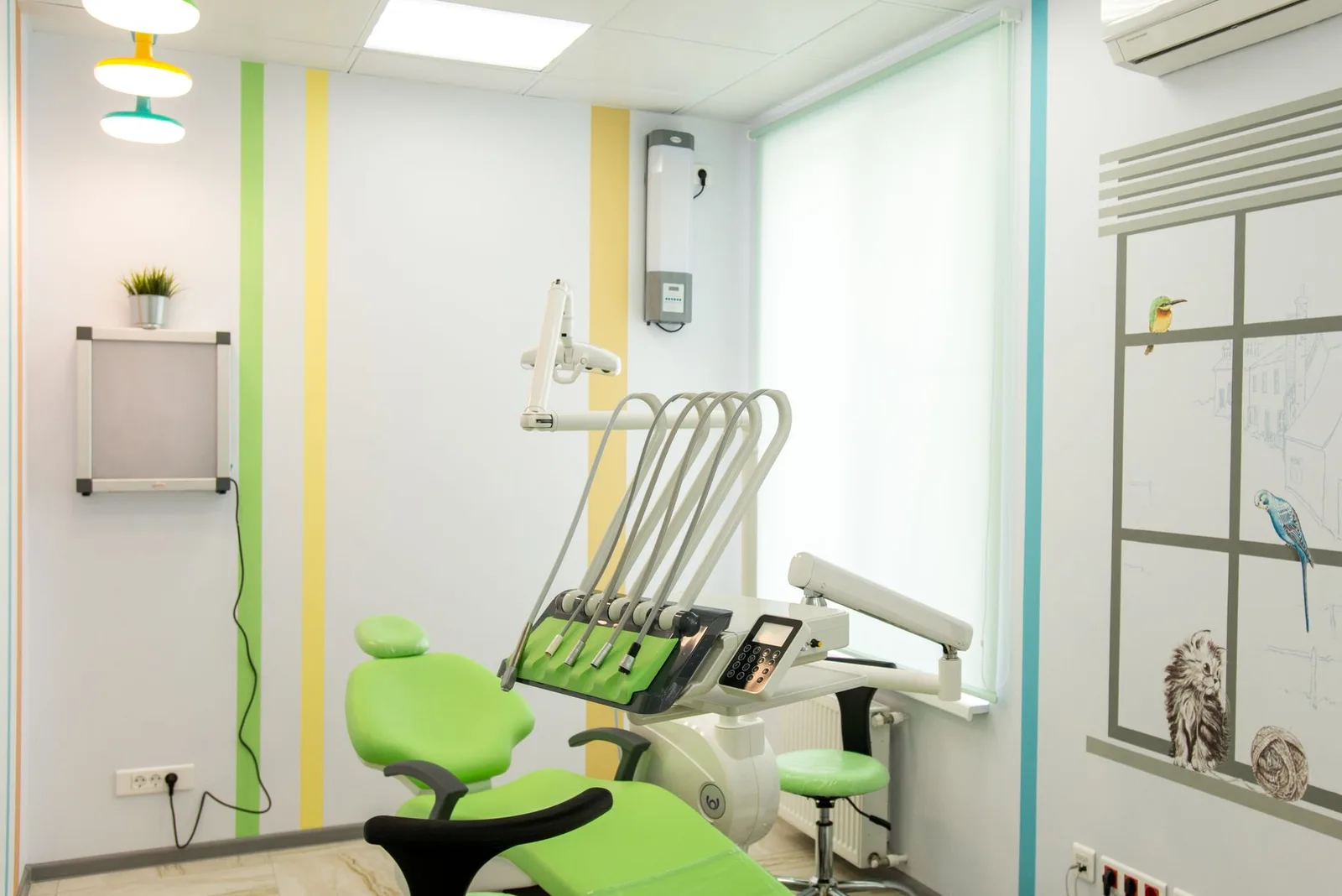 A bright, modern dental office interior featuring green accents and dental equipment.