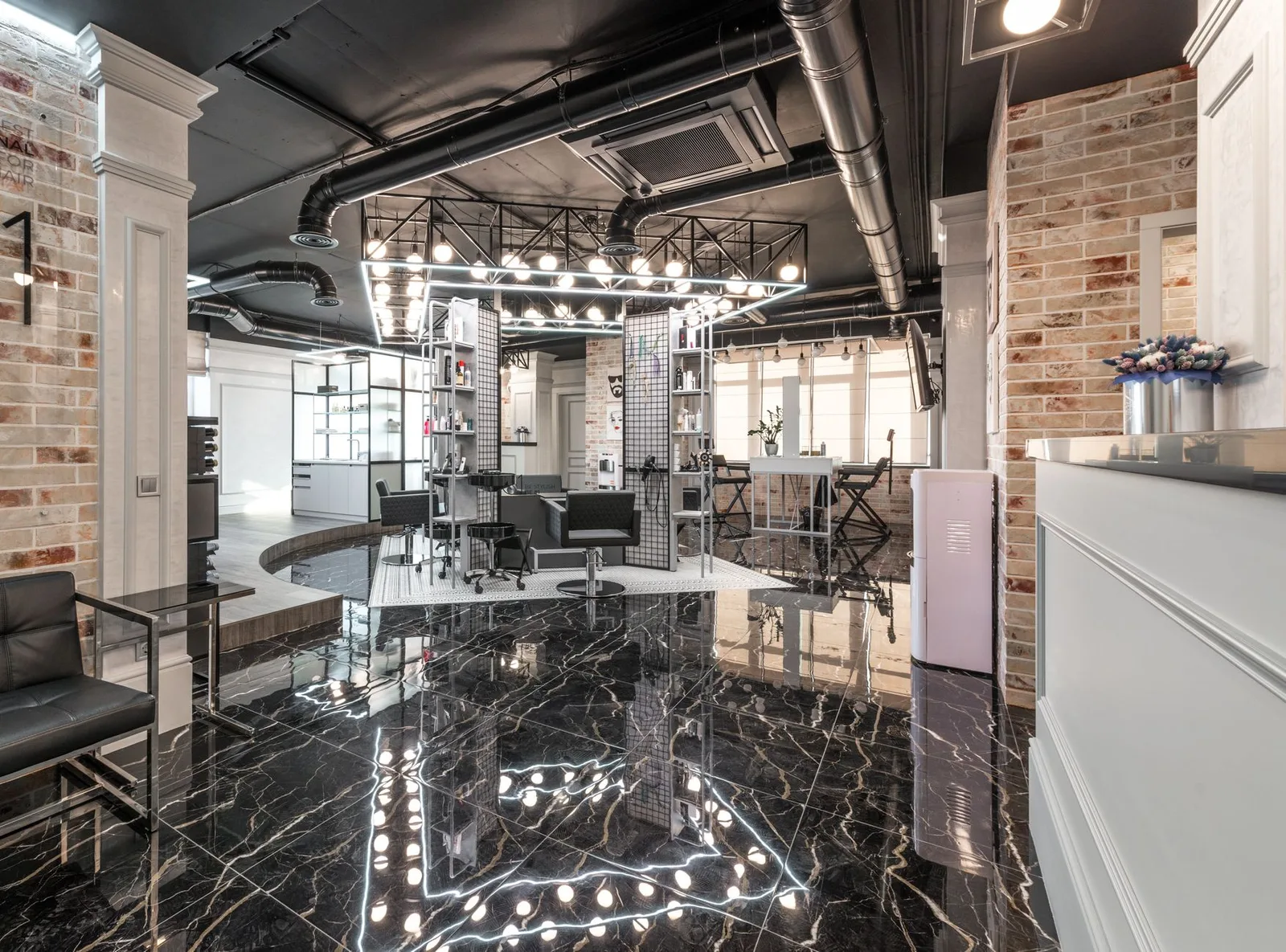 Reception desk with flowers placed in spacious light beauty salon with cosmetology equipment and shelves with supplies u