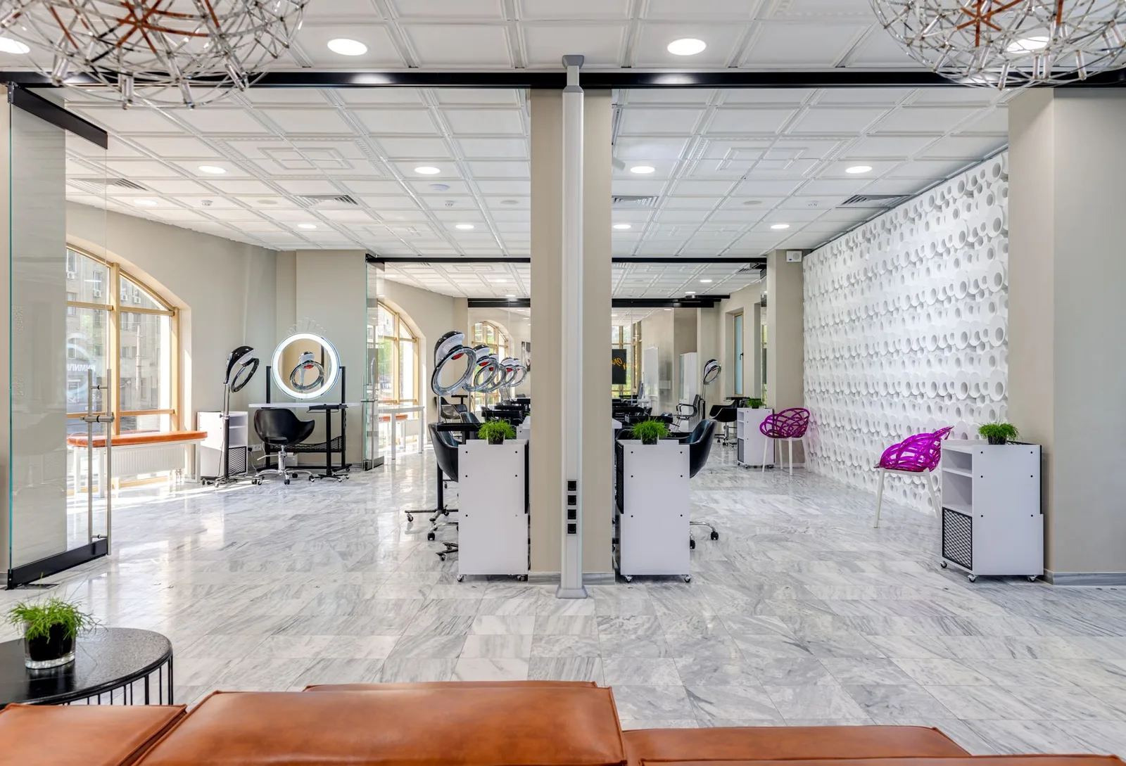 A sleek and modern beauty salon featuring chic design and comfortable seating areas.