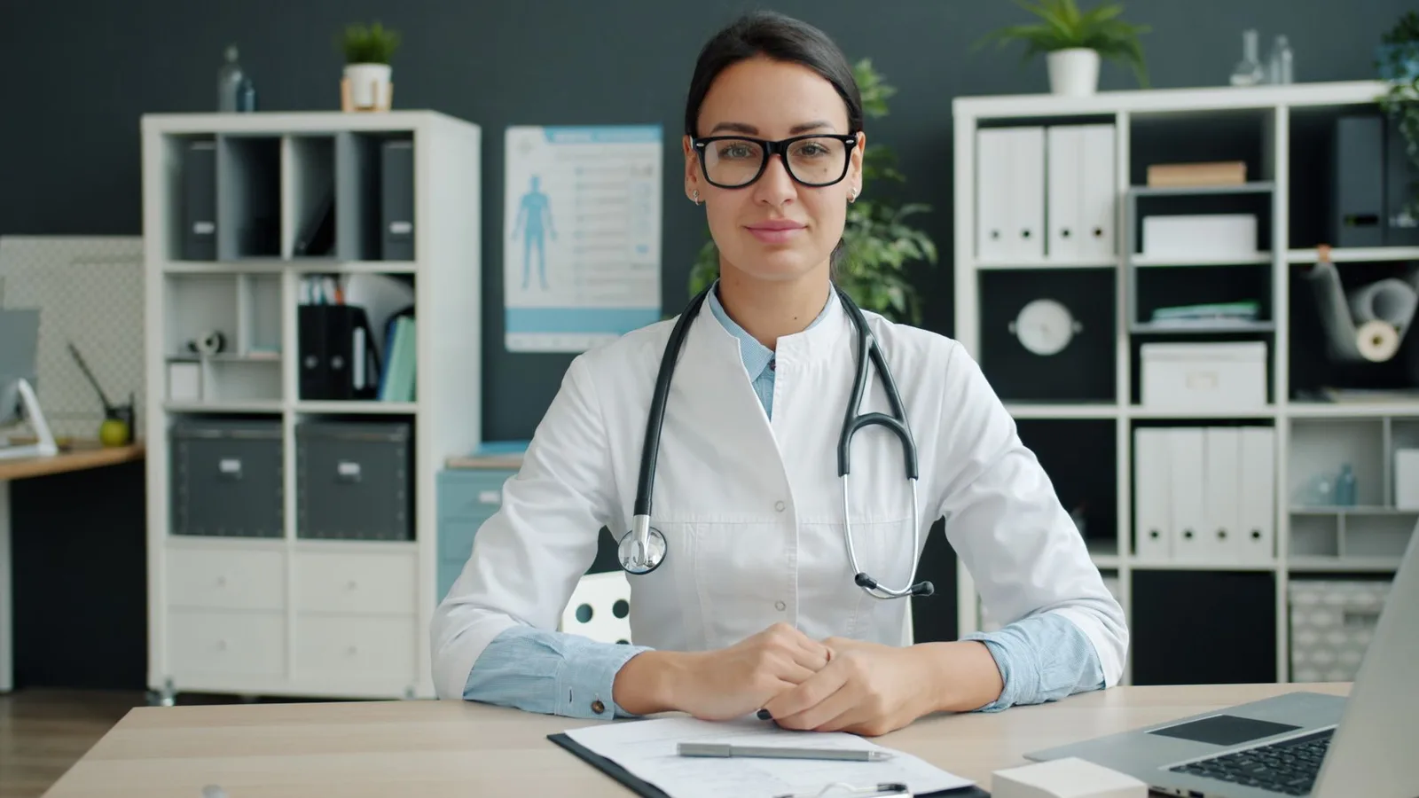Professional female doctor sits confidently in a modern office.